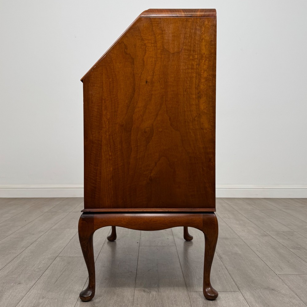 An Edwardian figured walnut writing bureau featuring a slant front above three drawers and carved cabriole legs. View IV