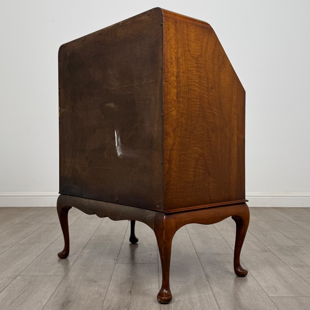 An Edwardian figured walnut writing bureau featuring a slant front above three drawers and carved cabriole legs. View VII