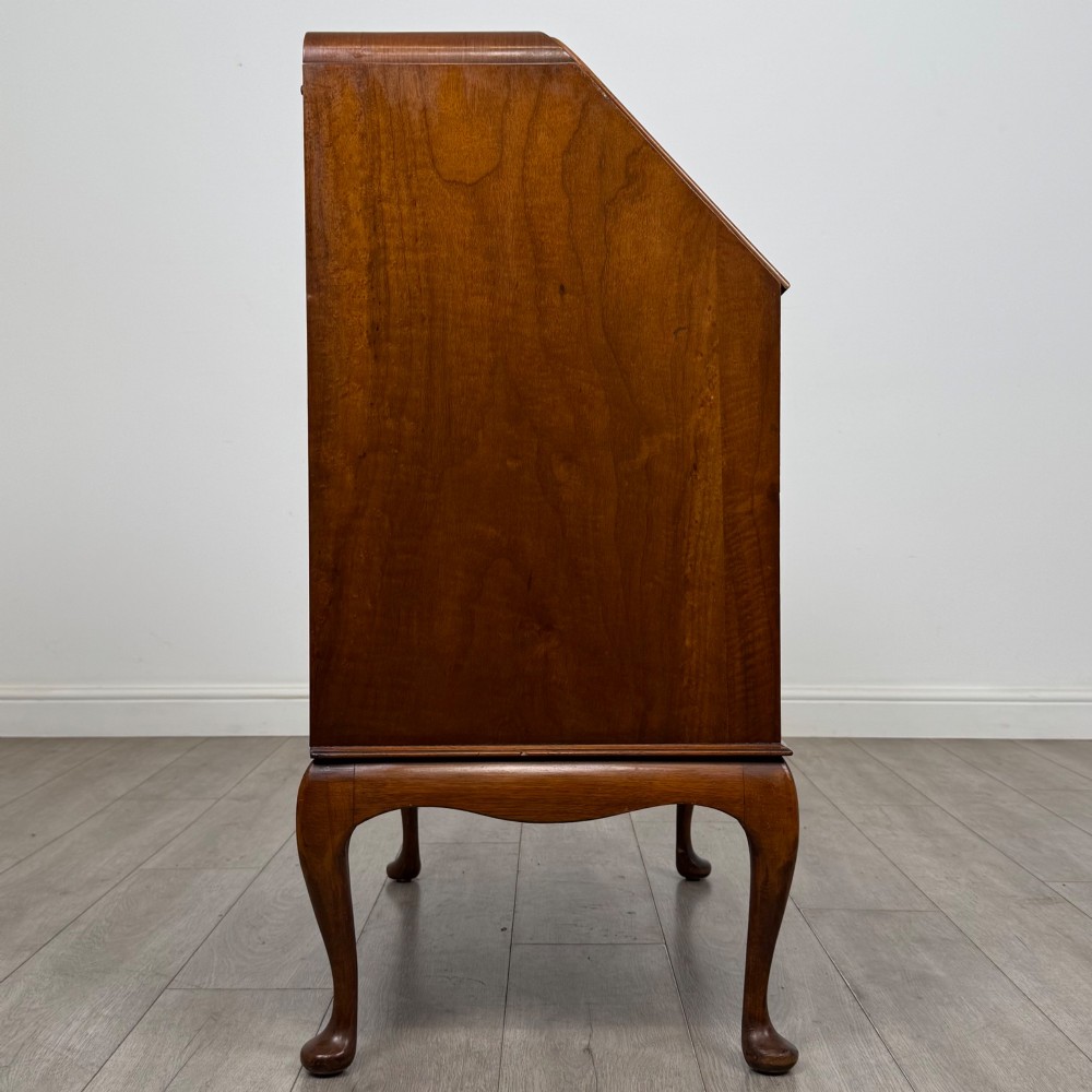 An Edwardian figured walnut writing bureau featuring a slant front above three drawers and carved cabriole legs. View VIII