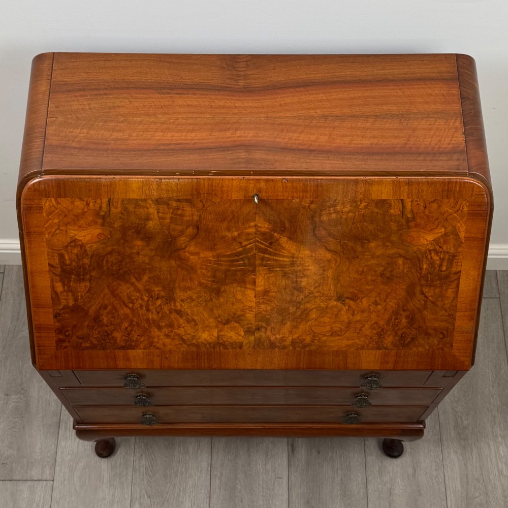 An Edwardian figured walnut writing bureau featuring a slant front above three drawers and carved cabriole legs. View X