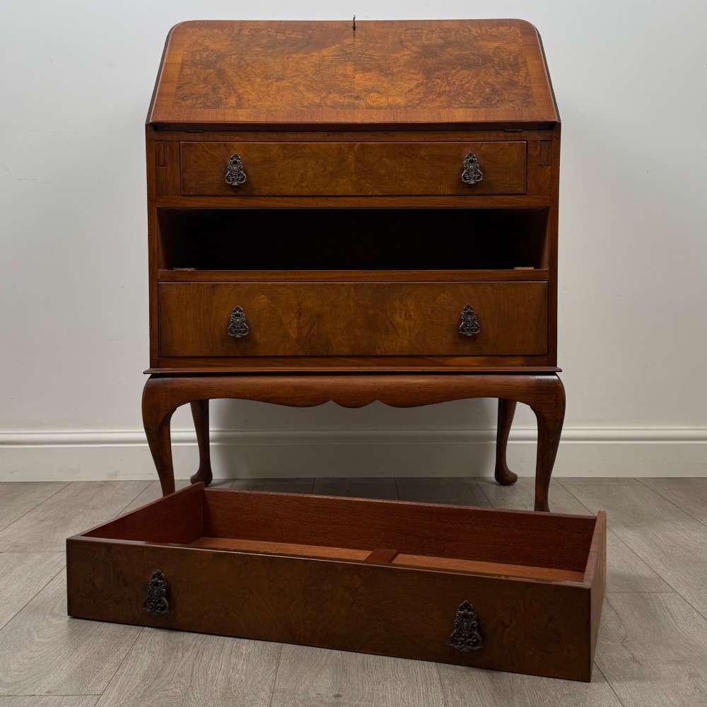 An Edwardian figured walnut writing bureau featuring a slant front above three drawers and carved cabriole legs. View XII