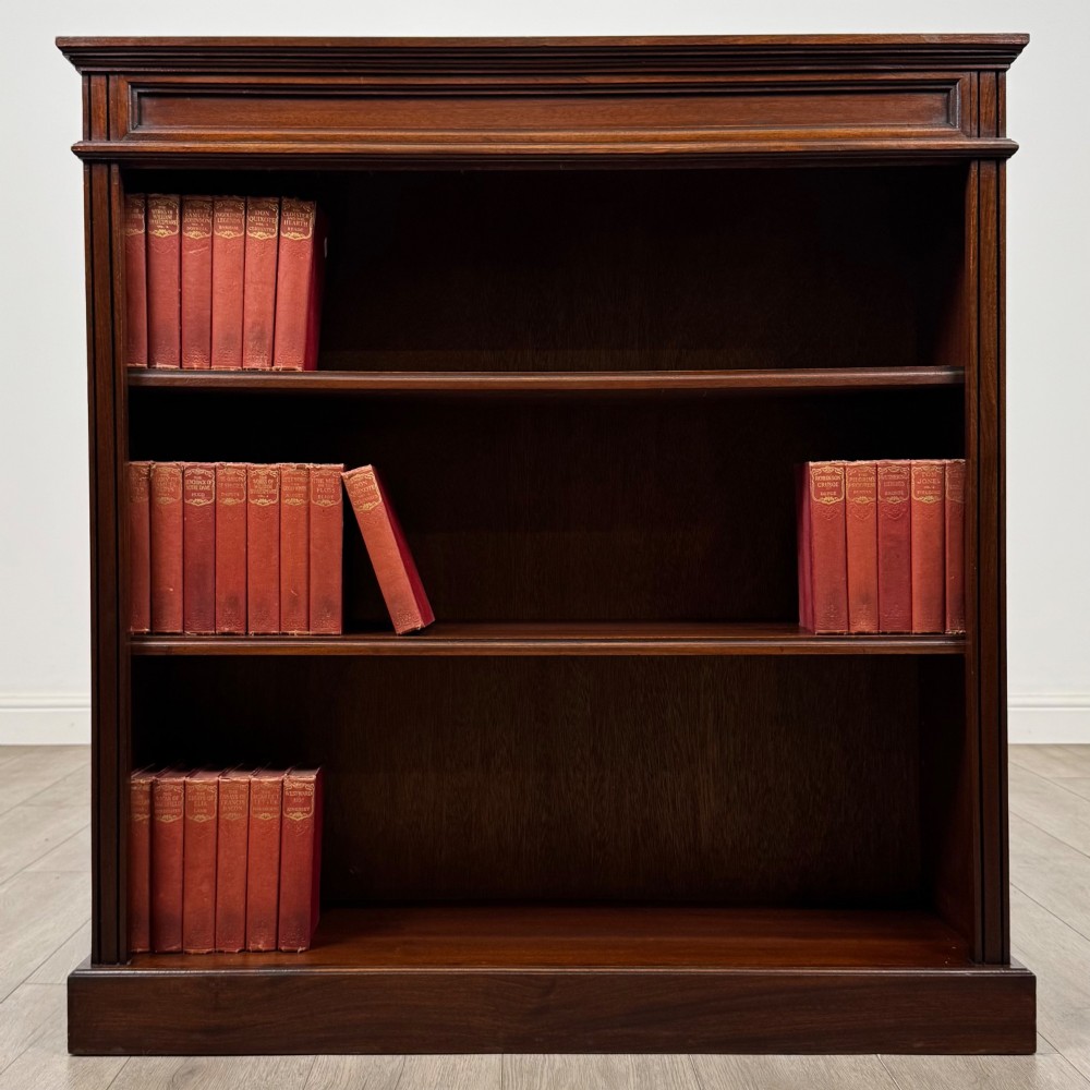 An early twentieth-century open mahogany bookcase featuring three wide horizontal shelves, a heavy moulded cornice, and a solid rectangular plinth base.