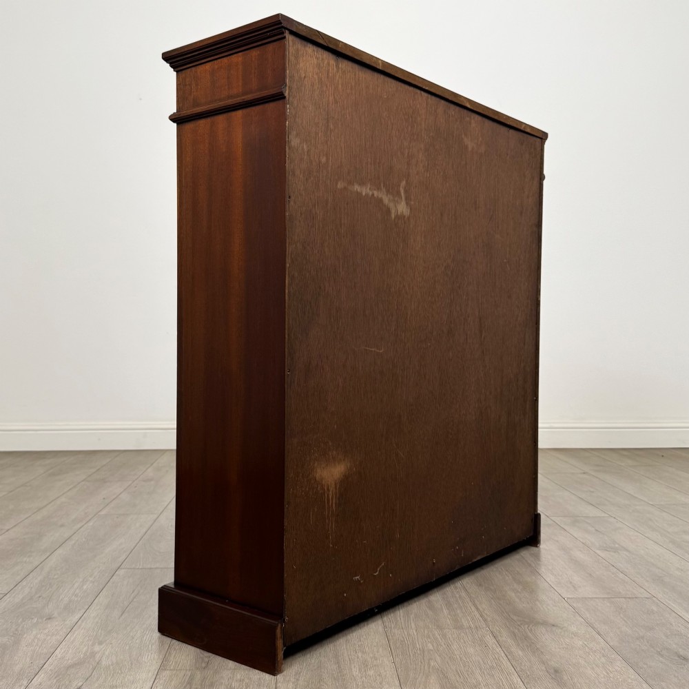 An early twentieth-century open mahogany bookcase featuring three wide horizontal shelves, a heavy moulded cornice, and a solid rectangular plinth base. View V