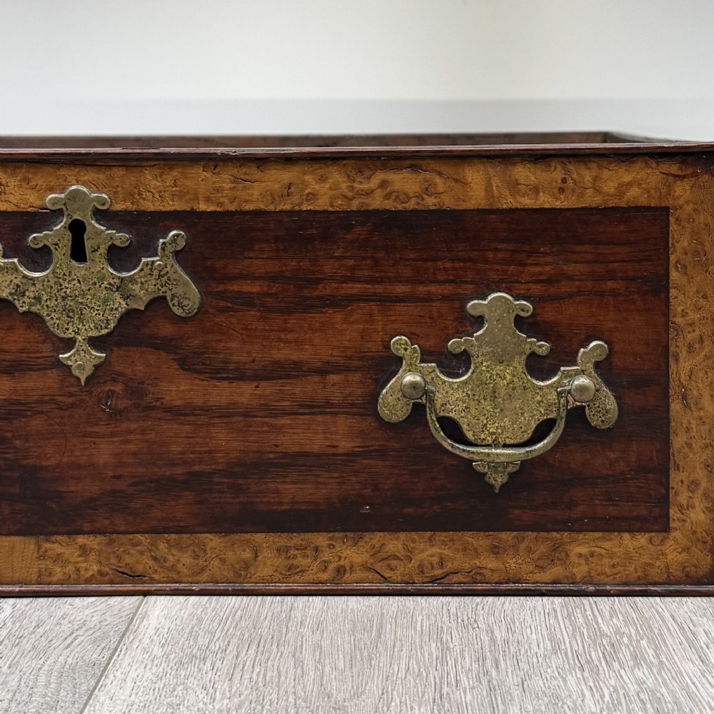 An antique dark oak dresser base featuring three crossbanded drawers with brass drop handles and keyhole escutcheons, supported by four straight square legs. View XI