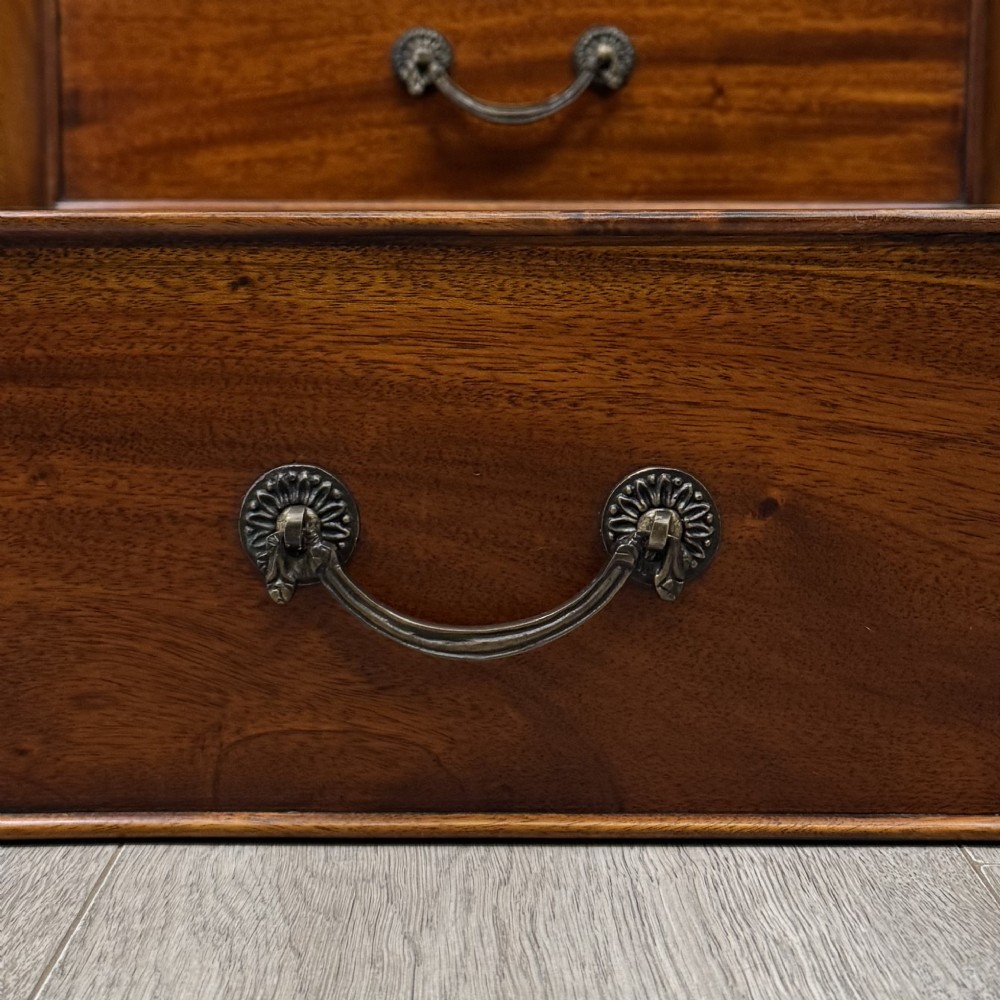A tall, narrow mahogany chest featuring seven drawers flanked by dark ebonised side columns on bracket feet. View XI