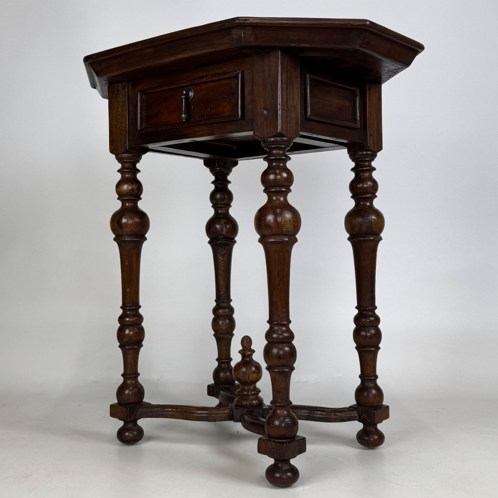 A dark brown hardwood octagonal side table with turned legs, a single drawer with a brass pull, and an arched cross-stretcher featuring a central finial. View II