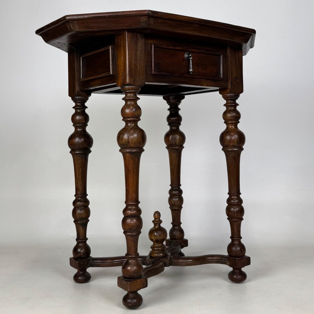 A dark brown hardwood octagonal side table with turned legs, a single drawer with a brass pull, and an arched cross-stretcher featuring a central finial. View VIII