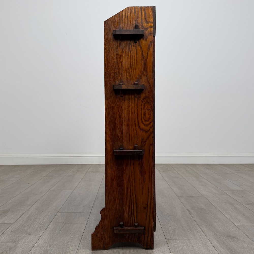 An early twentieth-century open golden oak bookcase featuring four wide wooden shelves and shaped side profile base. View IV