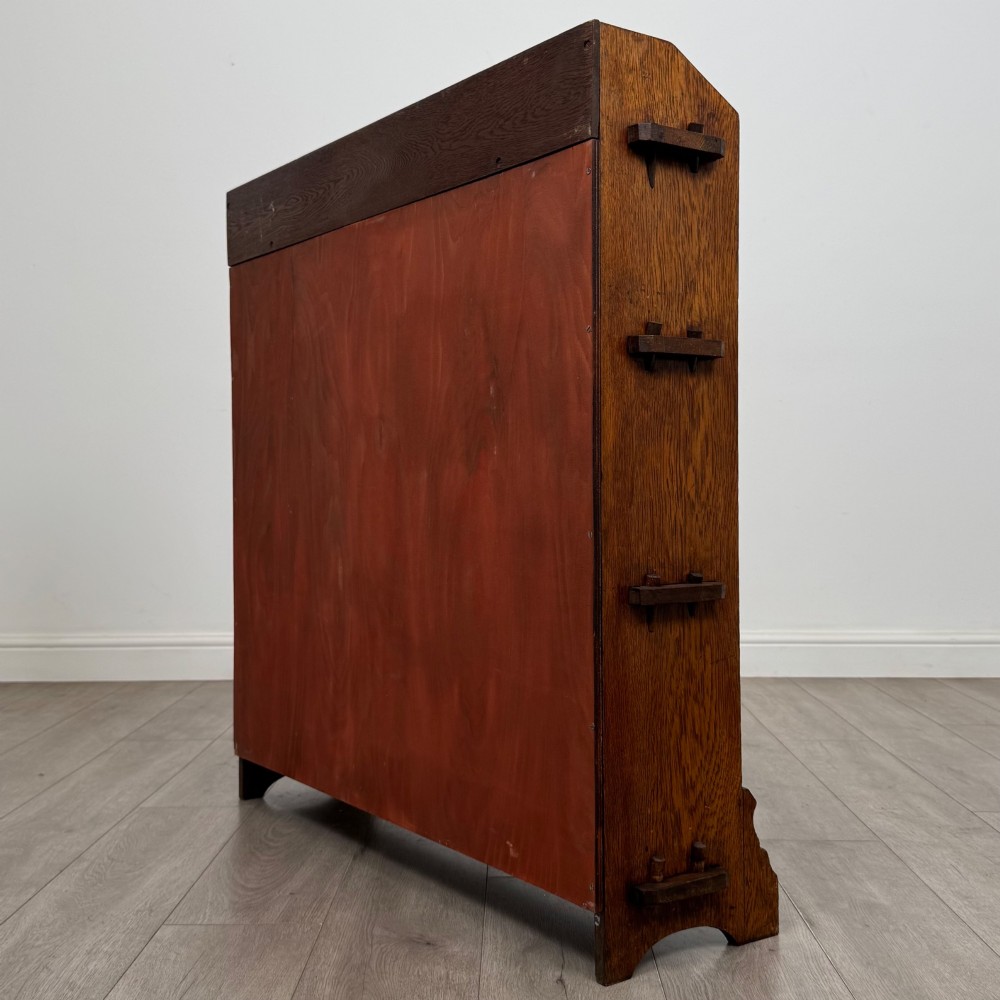 An early twentieth-century open golden oak bookcase featuring four wide wooden shelves and shaped side profile base. View VII