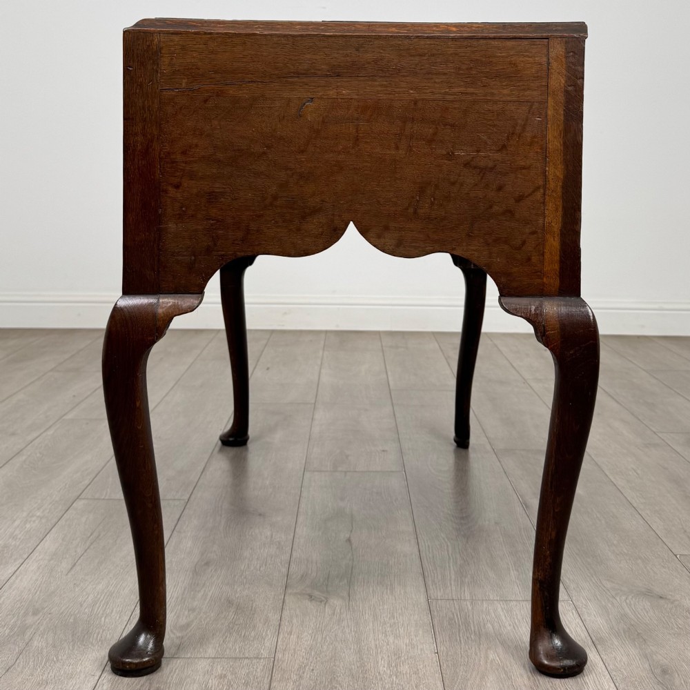 An 18th-century Georgian oak side table featuring three drawers with brass drop handles, an arched apron, and cabriole legs. View III