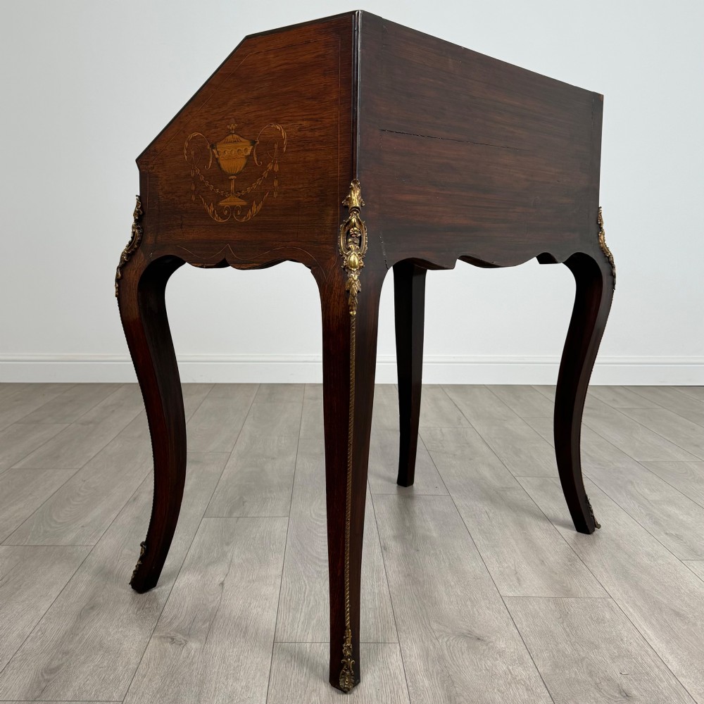 A 19th-century French rosewood bureau de dame with floral marquetry inlay on the hinged top and apron, raised on cabriole legs with gilt-bronze ormolu mounts. View V