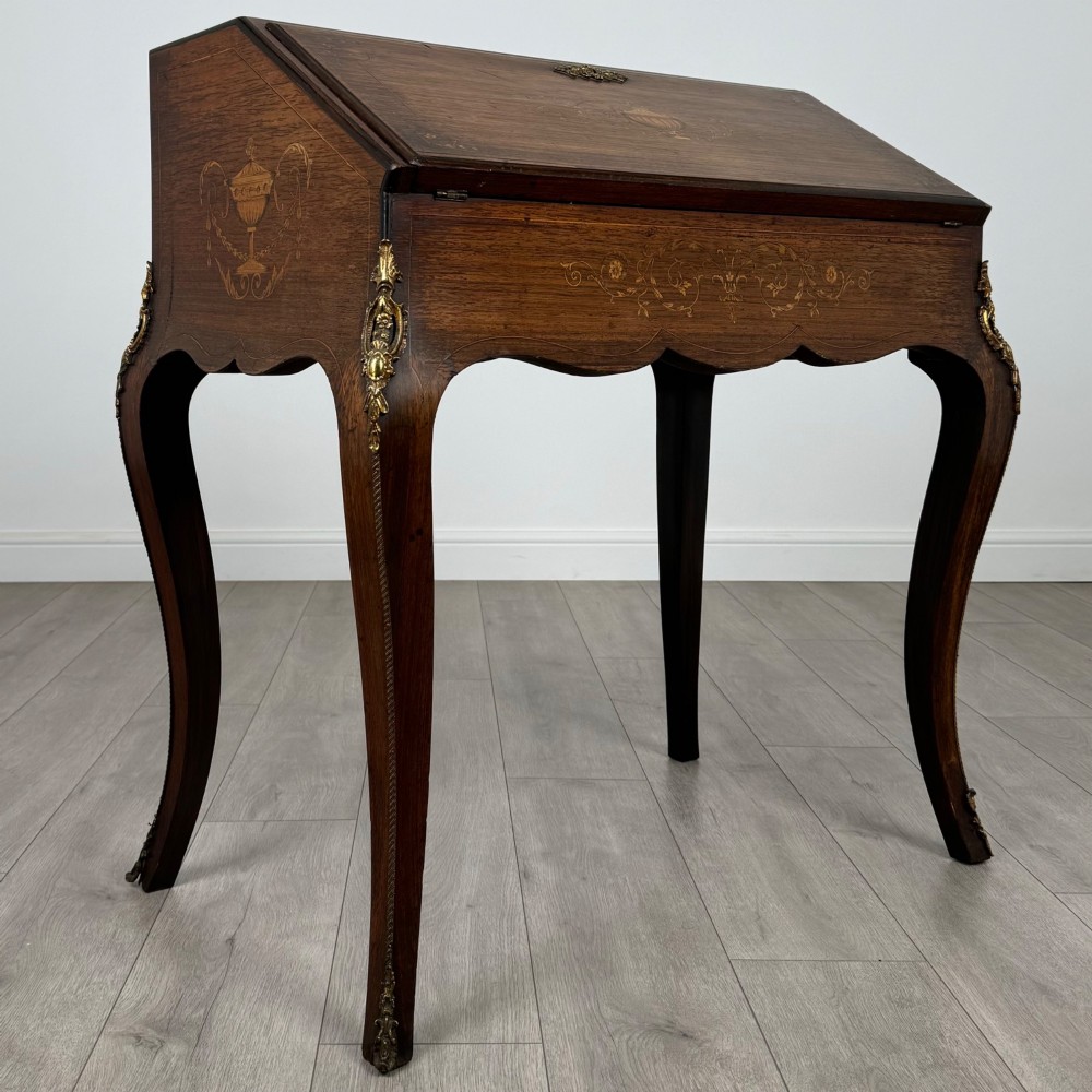 A 19th-century French rosewood bureau de dame with floral marquetry inlay on the hinged top and apron, raised on cabriole legs with gilt-bronze ormolu mounts. View IX