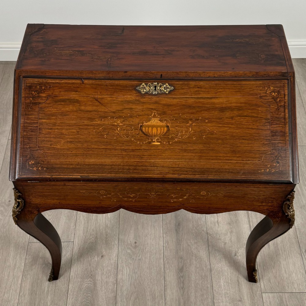 A 19th-century French rosewood bureau de dame with floral marquetry inlay on the hinged top and apron, raised on cabriole legs with gilt-bronze ormolu mounts. View X