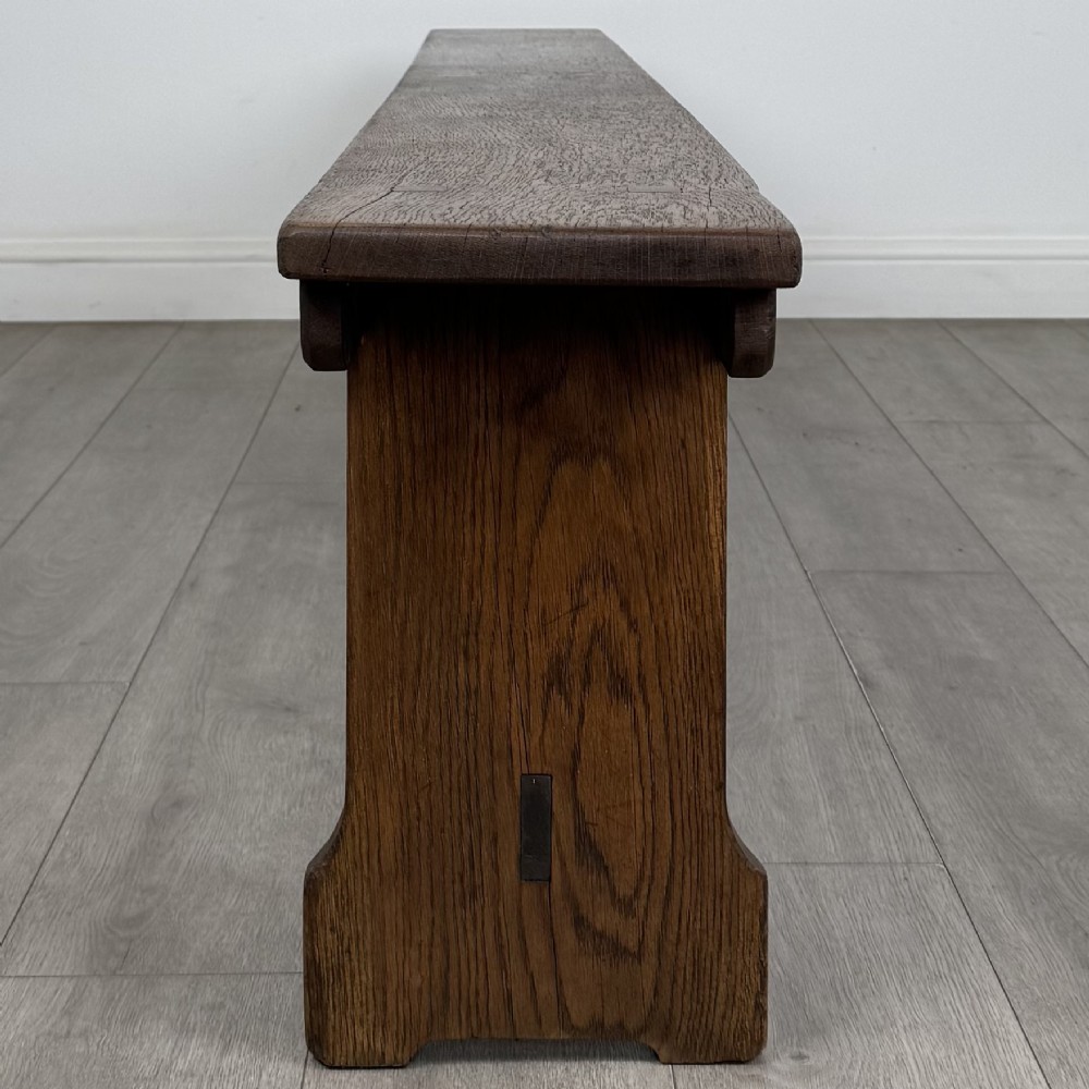 A long 19th-century Georgian oak tavern bench featuring a smooth plank seat supported by three sturdy slab legs and a full-length lower stretcher. View III