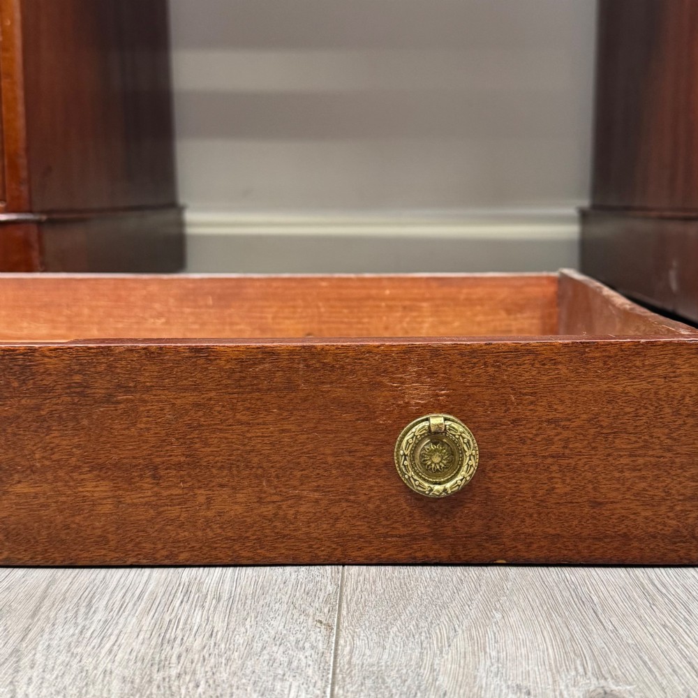 A 19th-century Victorian mahogany pedestal desk featuring nine drawers with circular brass knobs and keyholes, supported by twin plinth bases on casters. View XI