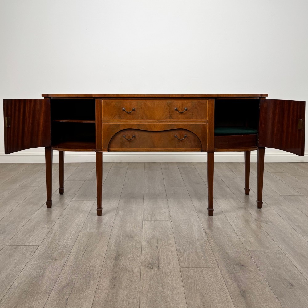 A 19th-century mahogany bow-front sideboard with central drawers, side cupboards, and tapered square legs. View II