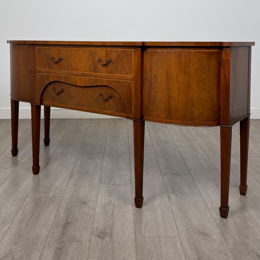 A 19th-century mahogany bow-front sideboard with central drawers, side cupboards, and tapered square legs. View III