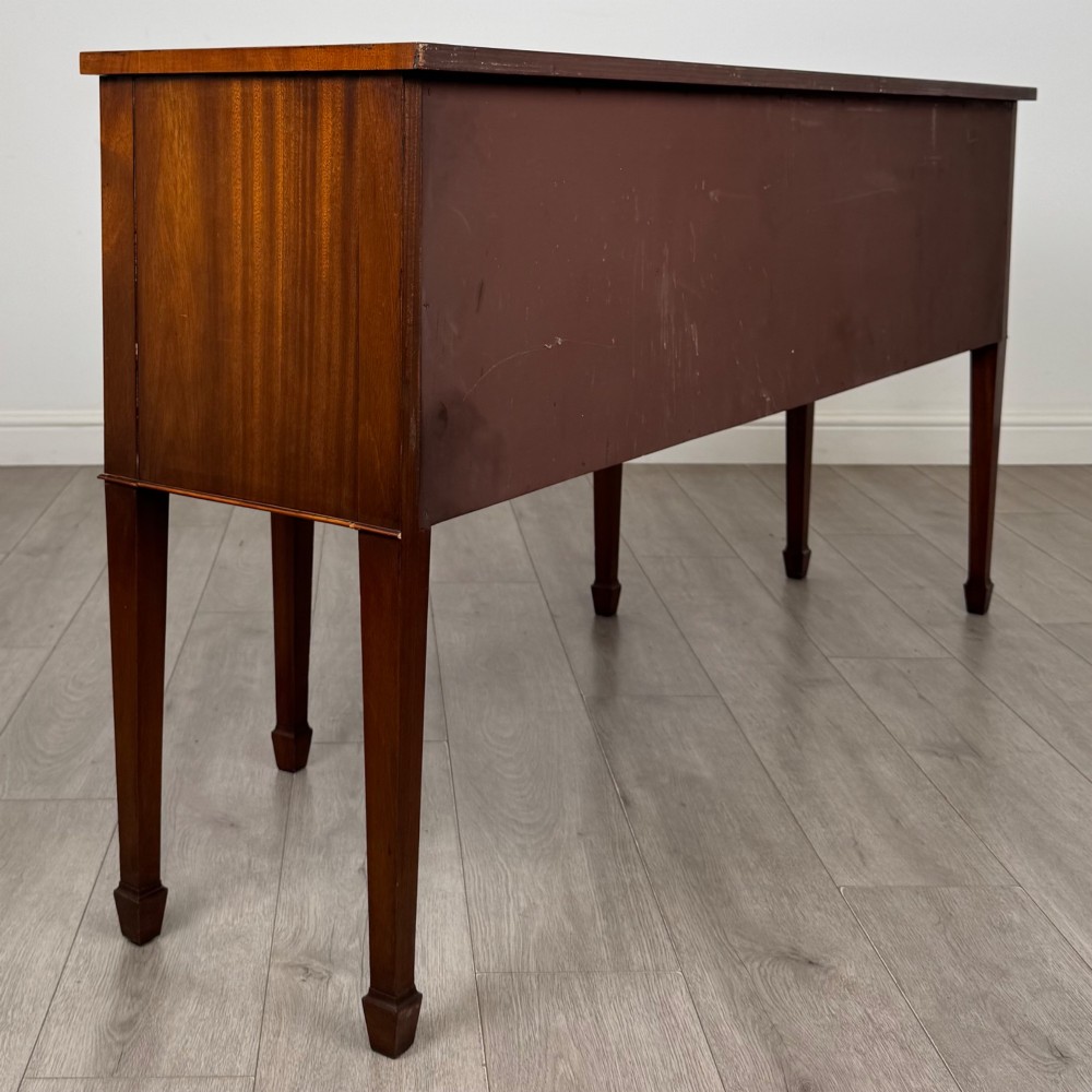 A 19th-century mahogany bow-front sideboard with central drawers, side cupboards, and tapered square legs. View V