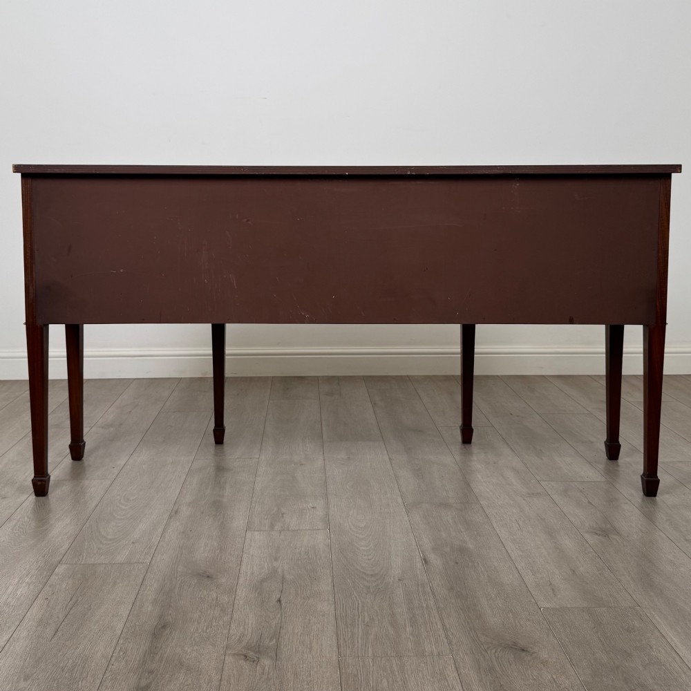 A 19th-century mahogany bow-front sideboard with central drawers, side cupboards, and tapered square legs. View VI