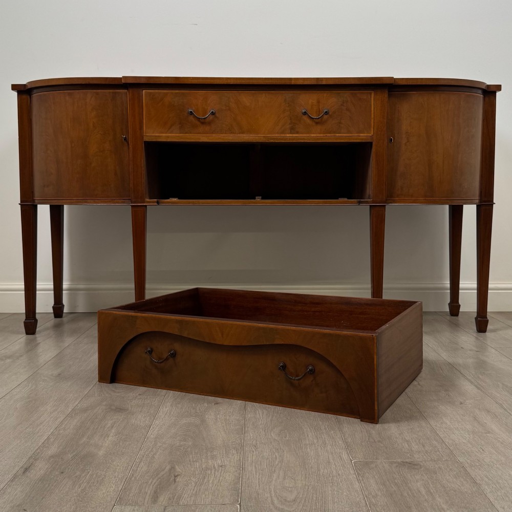 A 19th-century mahogany bow-front sideboard with central drawers, side cupboards, and tapered square legs. View XI