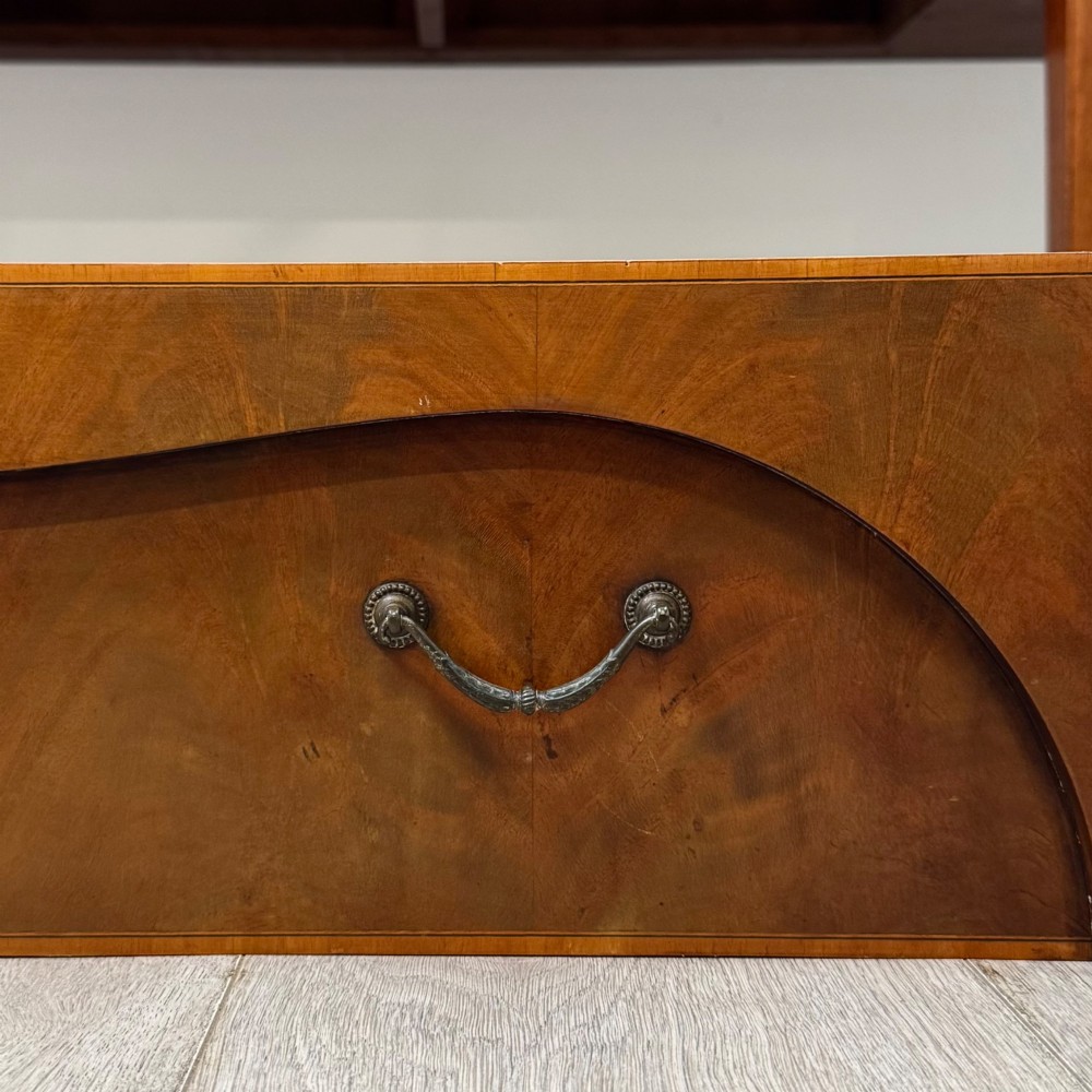 A 19th-century mahogany bow-front sideboard with central drawers, side cupboards, and tapered square legs. View XII