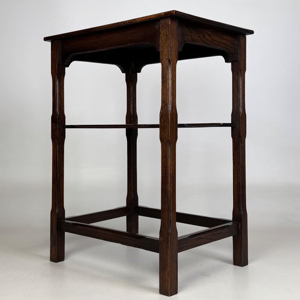 An Edwardian dark oak side table with a flat square top, lower tier shelf, shaped aprons, and straight square legs. View II