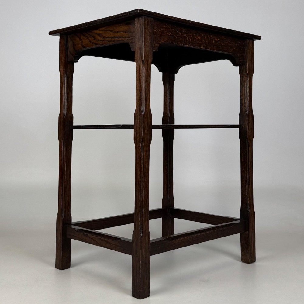 An Edwardian dark oak side table with a flat square top, lower tier shelf, shaped aprons, and straight square legs. View IV