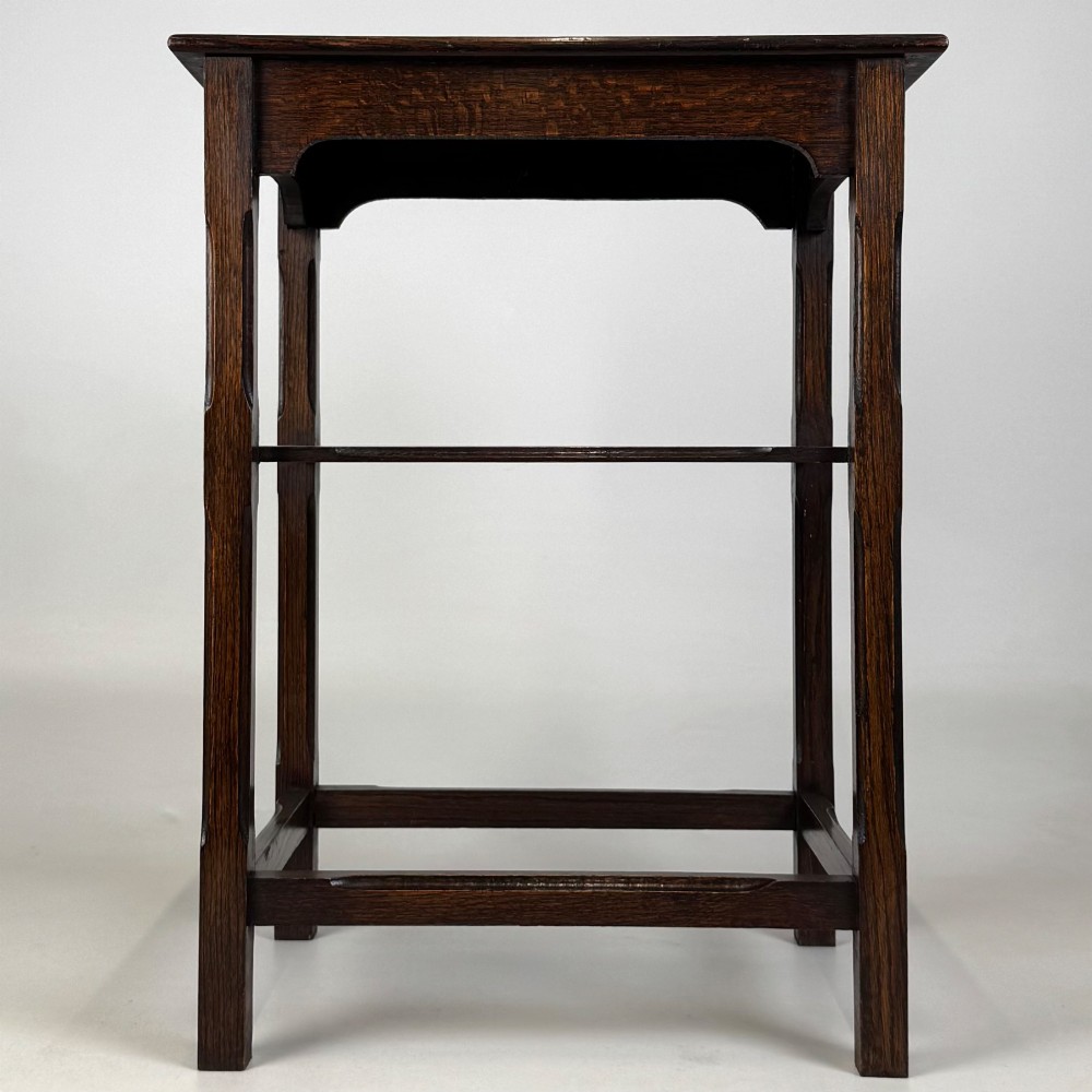 An Edwardian dark oak side table with a flat square top, lower tier shelf, shaped aprons, and straight square legs. View V