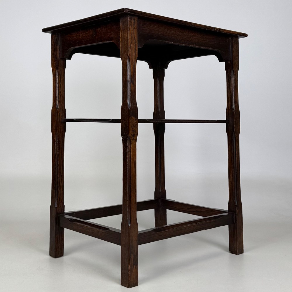 An Edwardian dark oak side table with a flat square top, lower tier shelf, shaped aprons, and straight square legs. View VIII