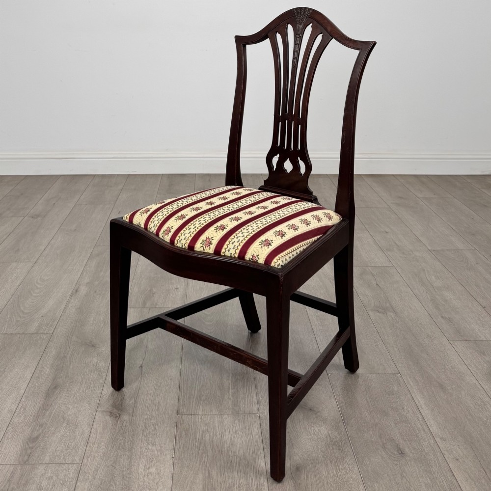 A set of eight dark mahogany shield back dining chairs, including two carvers and six side chairs, with striped red and cream upholstery. View III
