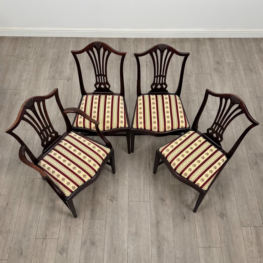 A set of eight dark mahogany shield back dining chairs, including two carvers and six side chairs, with striped red and cream upholstery. View VIII