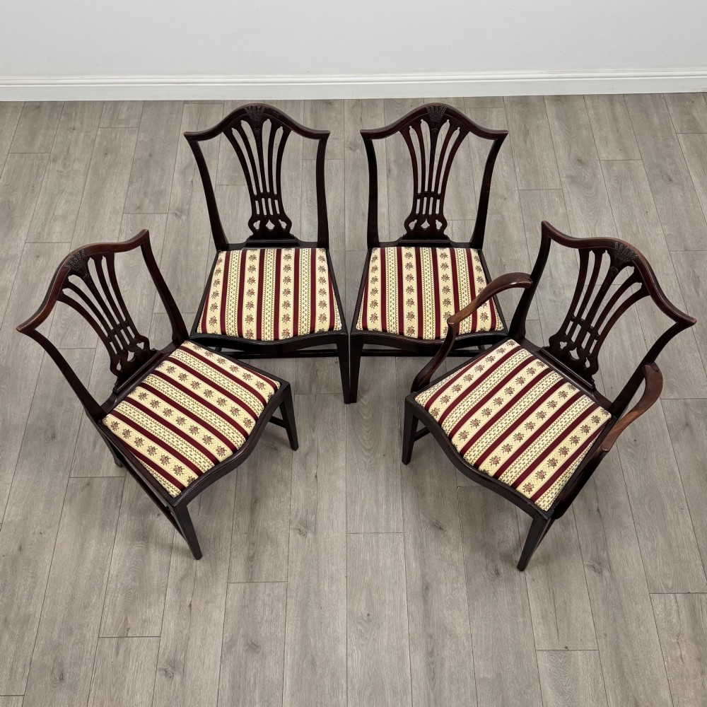 A set of eight dark mahogany shield back dining chairs, including two carvers and six side chairs, with striped red and cream upholstery. View IX