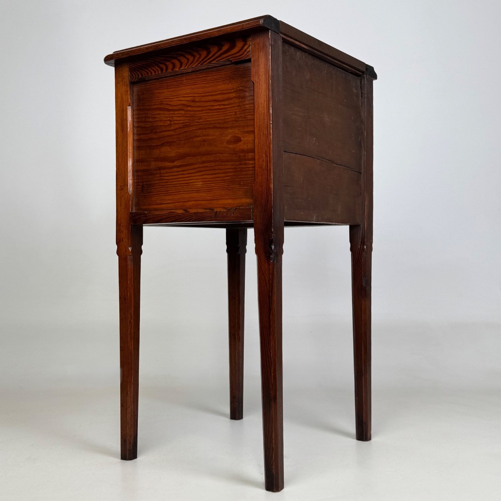 A Victorian pitch pine cabinet with three drawers and black wooden knobs set on elevated tapered square legs. View IV