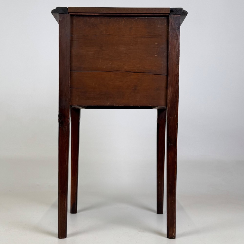 A Victorian pitch pine cabinet with three drawers and black wooden knobs set on elevated tapered square legs. View V