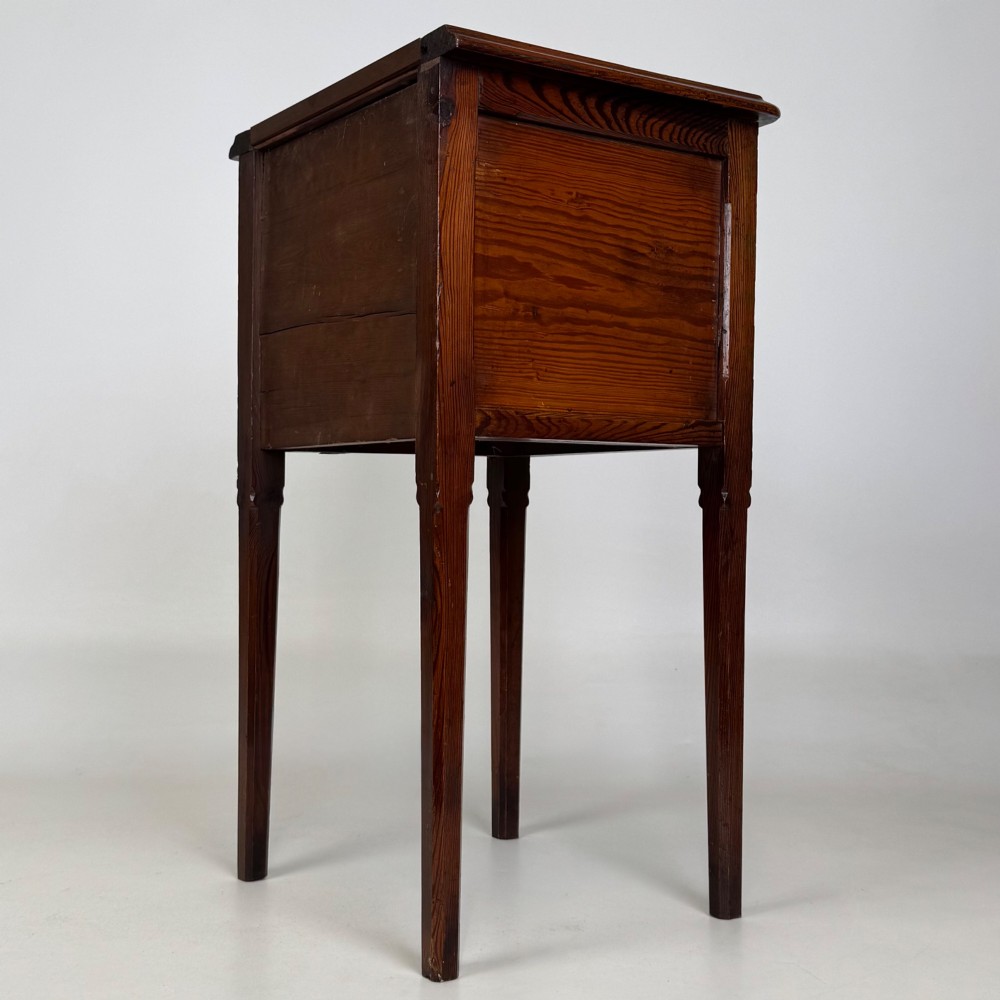 A Victorian pitch pine cabinet with three drawers and black wooden knobs set on elevated tapered square legs. View VI