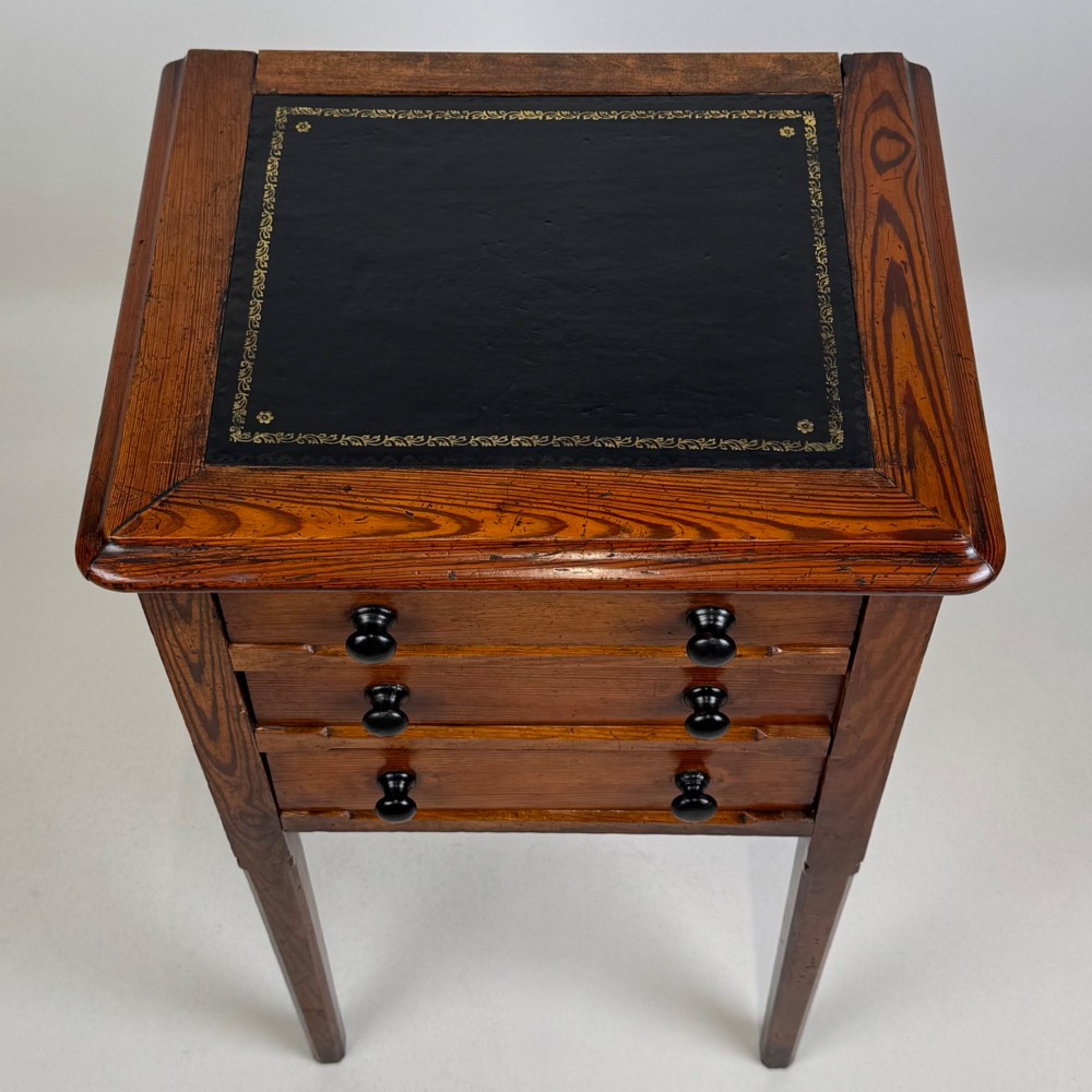A Victorian pitch pine cabinet with three drawers and black wooden knobs set on elevated tapered square legs. View IX