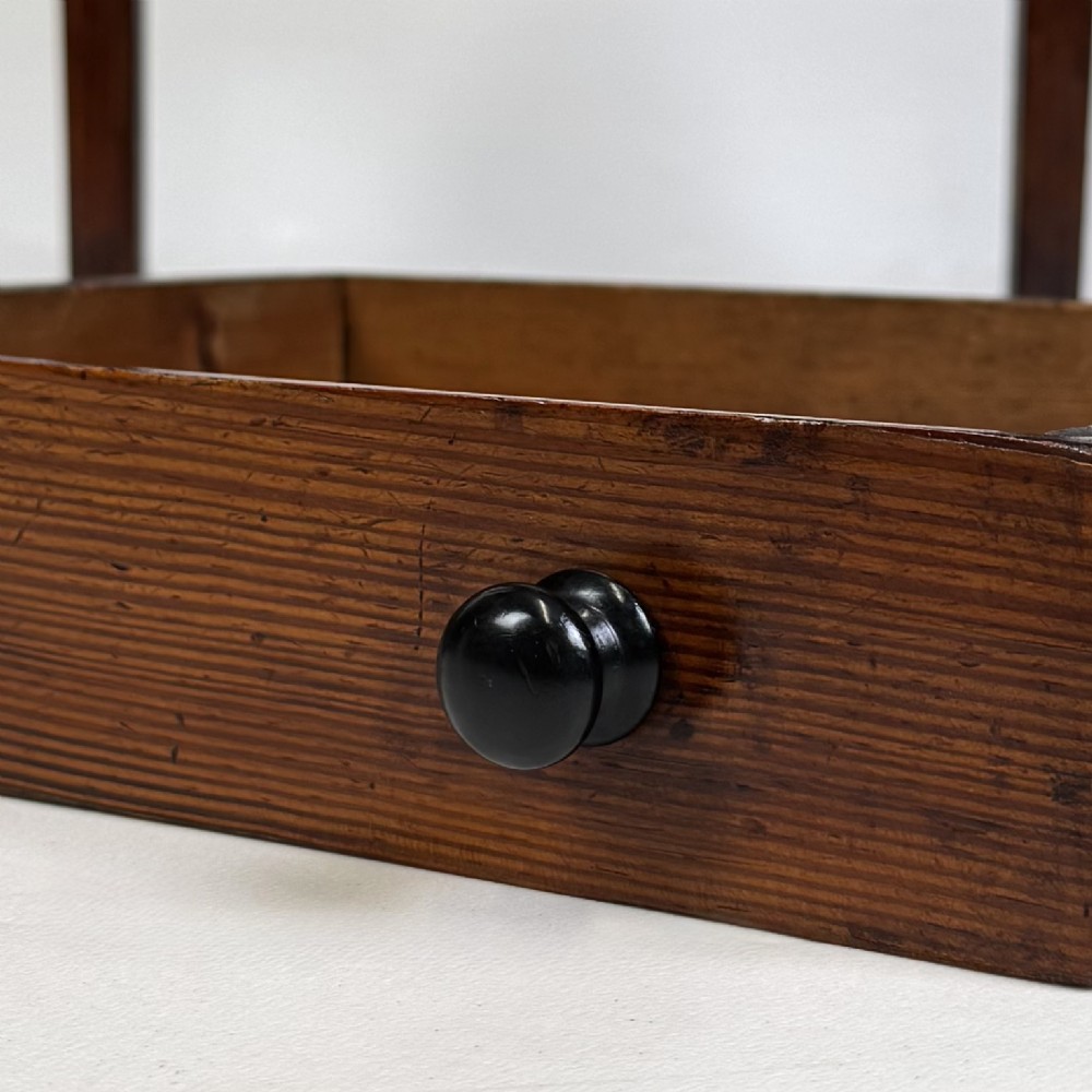 A Victorian pitch pine cabinet with three drawers and black wooden knobs set on elevated tapered square legs. View XI