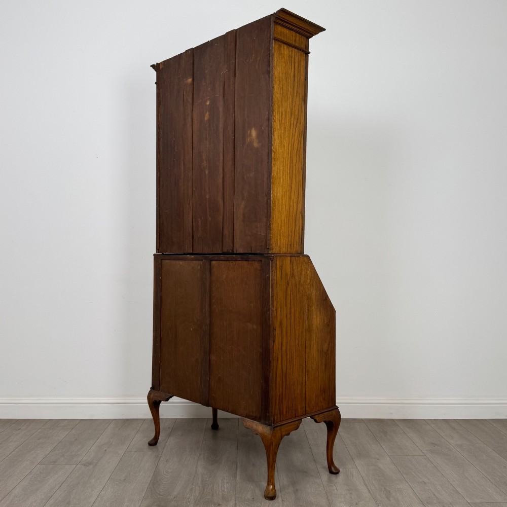 An Edwardian oak bureau bookcase with a two-door upper glazed display cabinet, a sloping drop-front desk, three wide drawers, and cabriole legs. View VIII