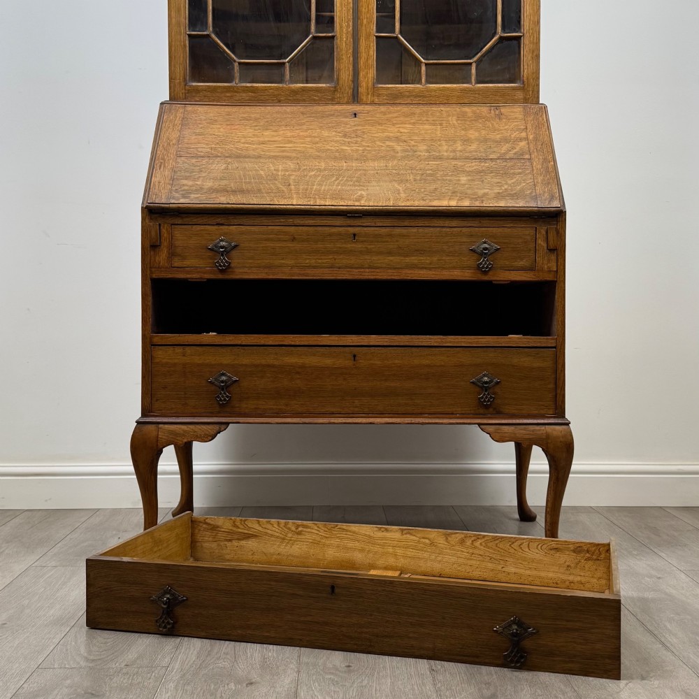 An Edwardian oak bureau bookcase with a two-door upper glazed display cabinet, a sloping drop-front desk, three wide drawers, and cabriole legs. View XIII