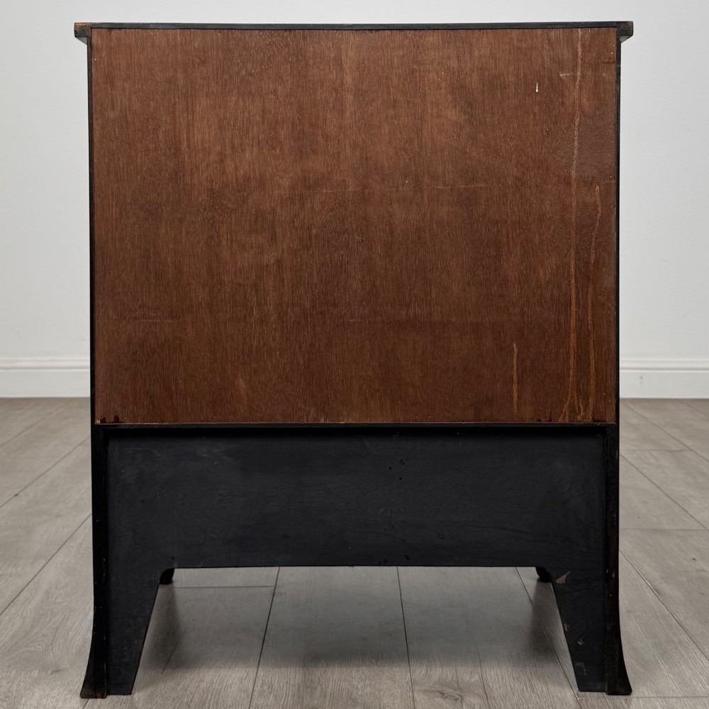 A 20th-century mahogany serpentine cupboard featuring flame mahogany oval door panels, chevron veneering, a lower drawer with brass ring handles, and splayed bracket feet. View VI