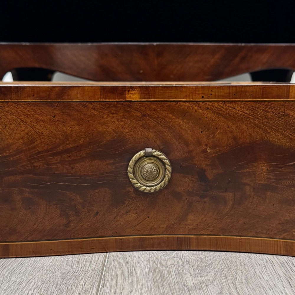 A 20th-century mahogany serpentine cupboard featuring flame mahogany oval door panels, chevron veneering, a lower drawer with brass ring handles, and splayed bracket feet. View XII