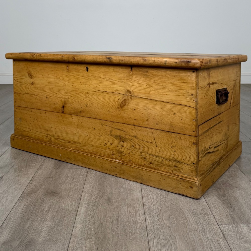 A 19th-century Victorian pine blanket box featuring a flat hinged lid, visible wood grain, central keyhole, and solid plinth base. View II