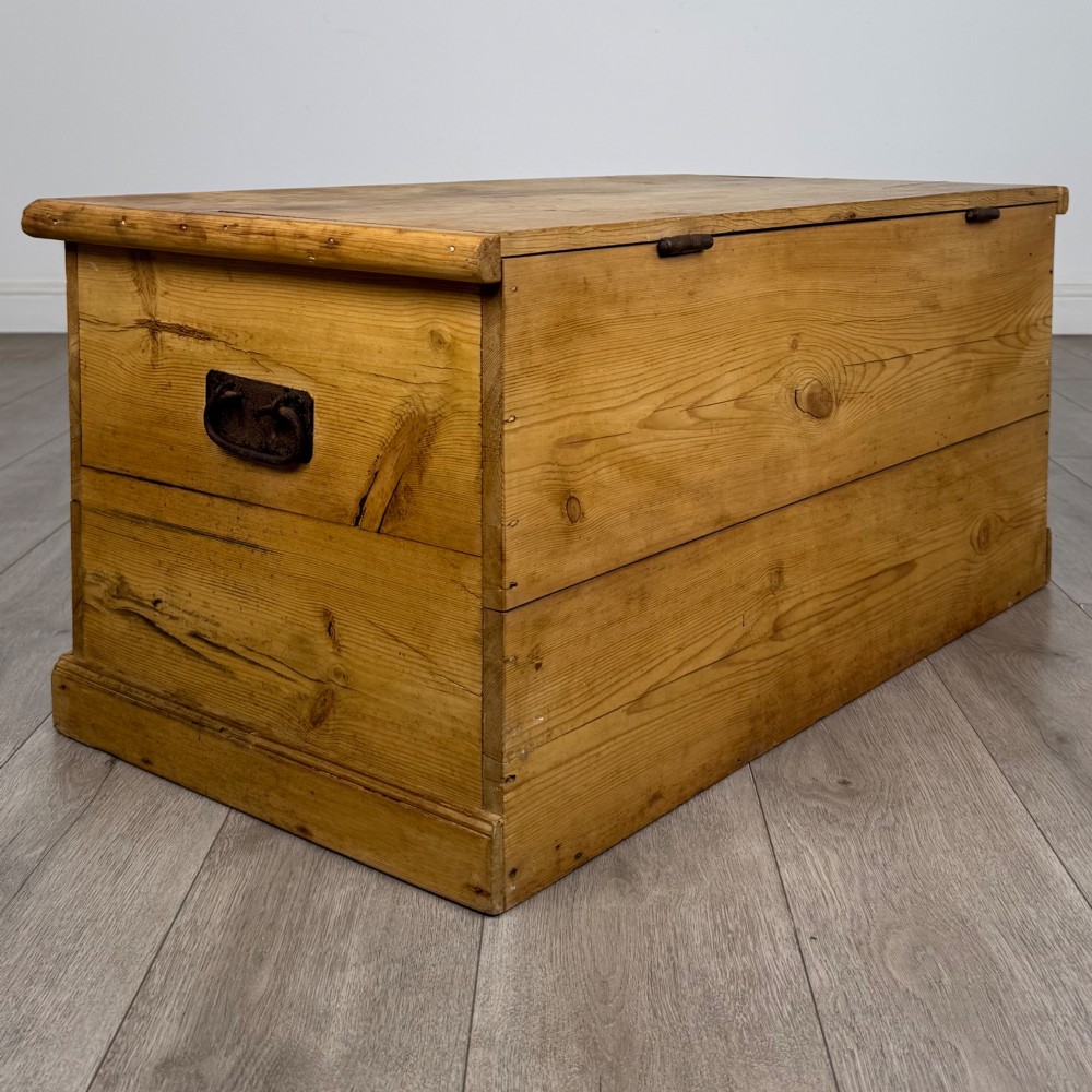 A 19th-century Victorian pine blanket box featuring a flat hinged lid, visible wood grain, central keyhole, and solid plinth base. View IV