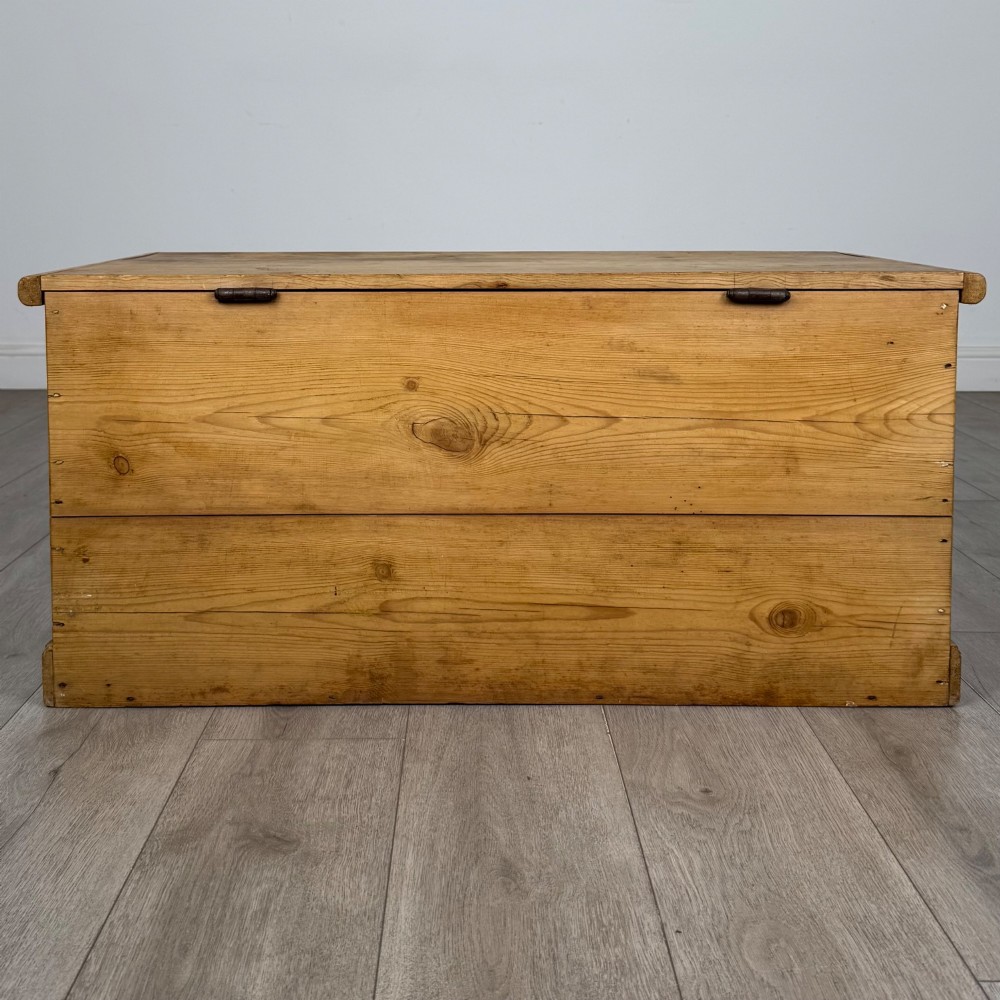A 19th-century Victorian pine blanket box featuring a flat hinged lid, visible wood grain, central keyhole, and solid plinth base. View V