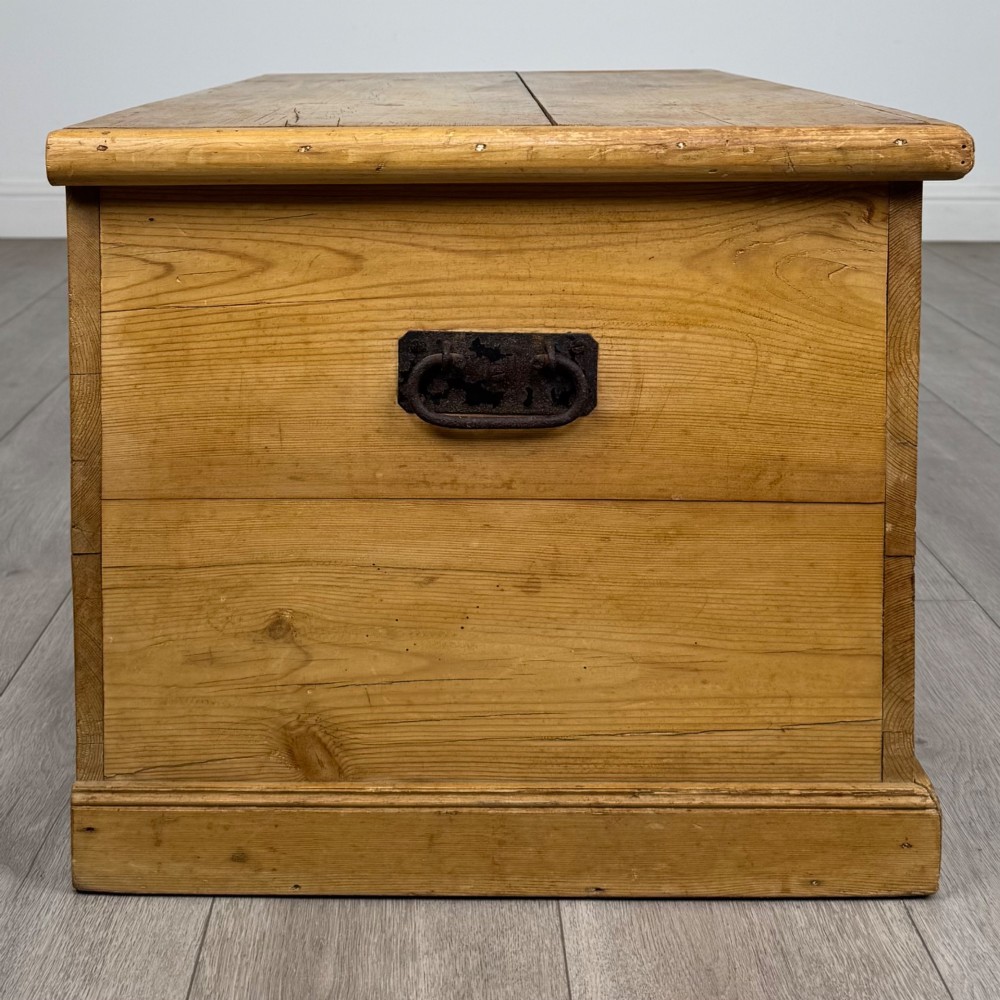 A 19th-century Victorian pine blanket box featuring a flat hinged lid, visible wood grain, central keyhole, and solid plinth base. View VII