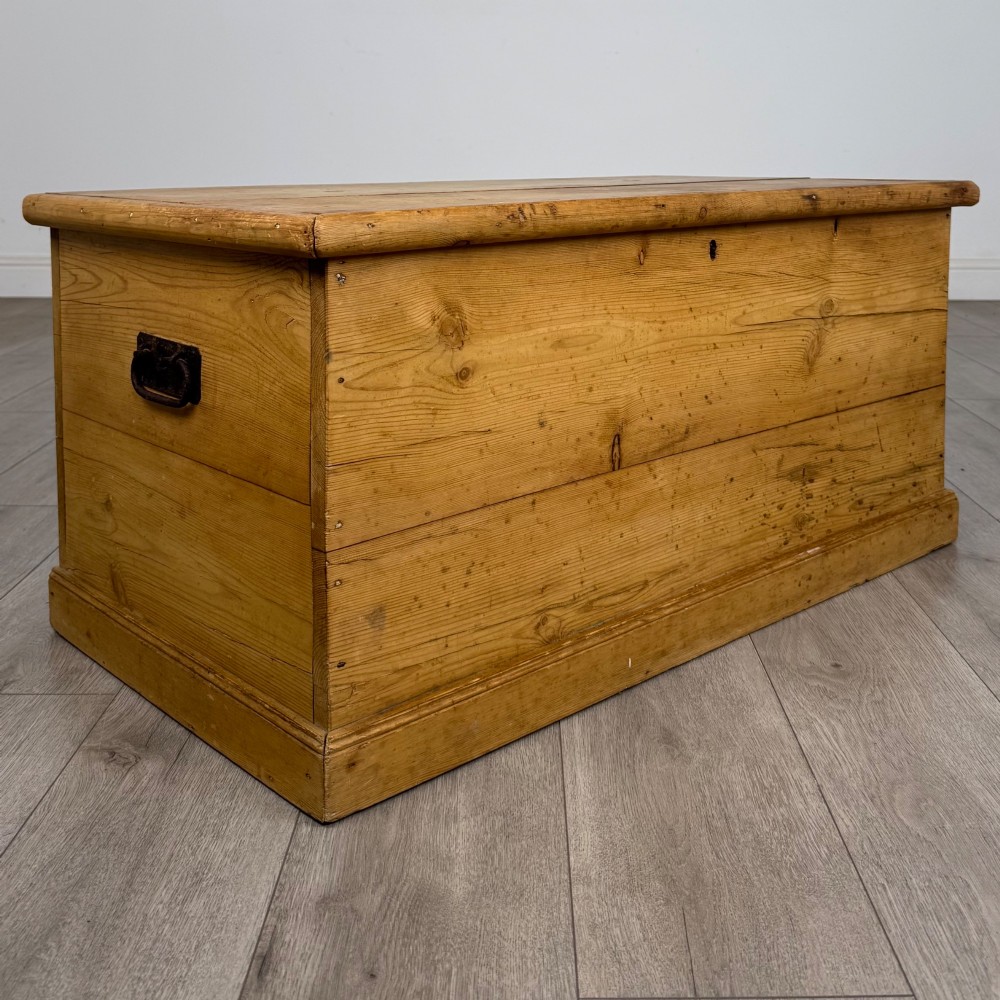 A 19th-century Victorian pine blanket box featuring a flat hinged lid, visible wood grain, central keyhole, and solid plinth base. View VIII