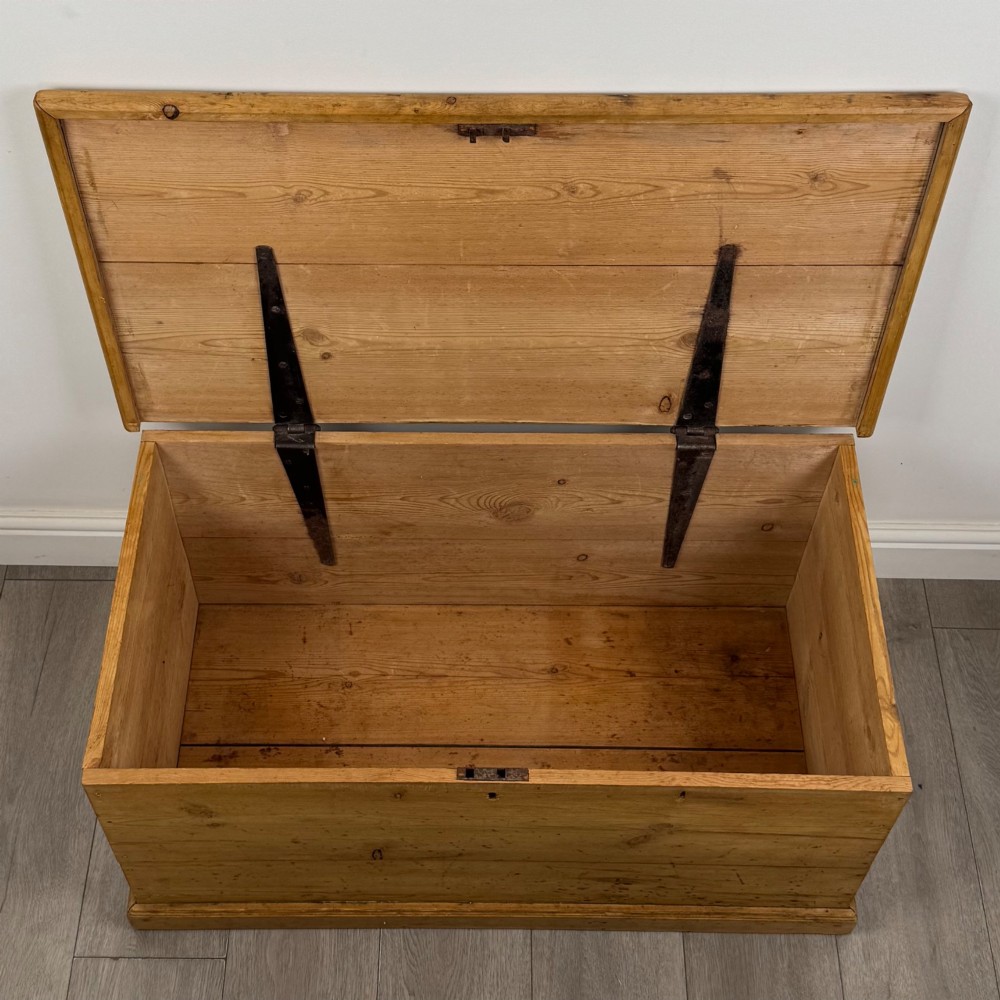 A 19th-century Victorian pine blanket box featuring a flat hinged lid, visible wood grain, central keyhole, and solid plinth base. View X