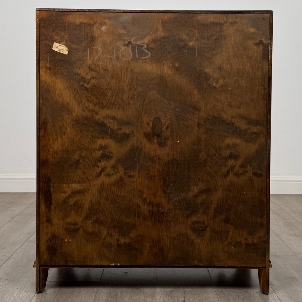 A dark oak slant-front writing bureau featuring carved linenfold upper panels, a single carved drawer with wooden knobs, and a double-door cupboard base decorated with diamond lozenge carvings. View VI