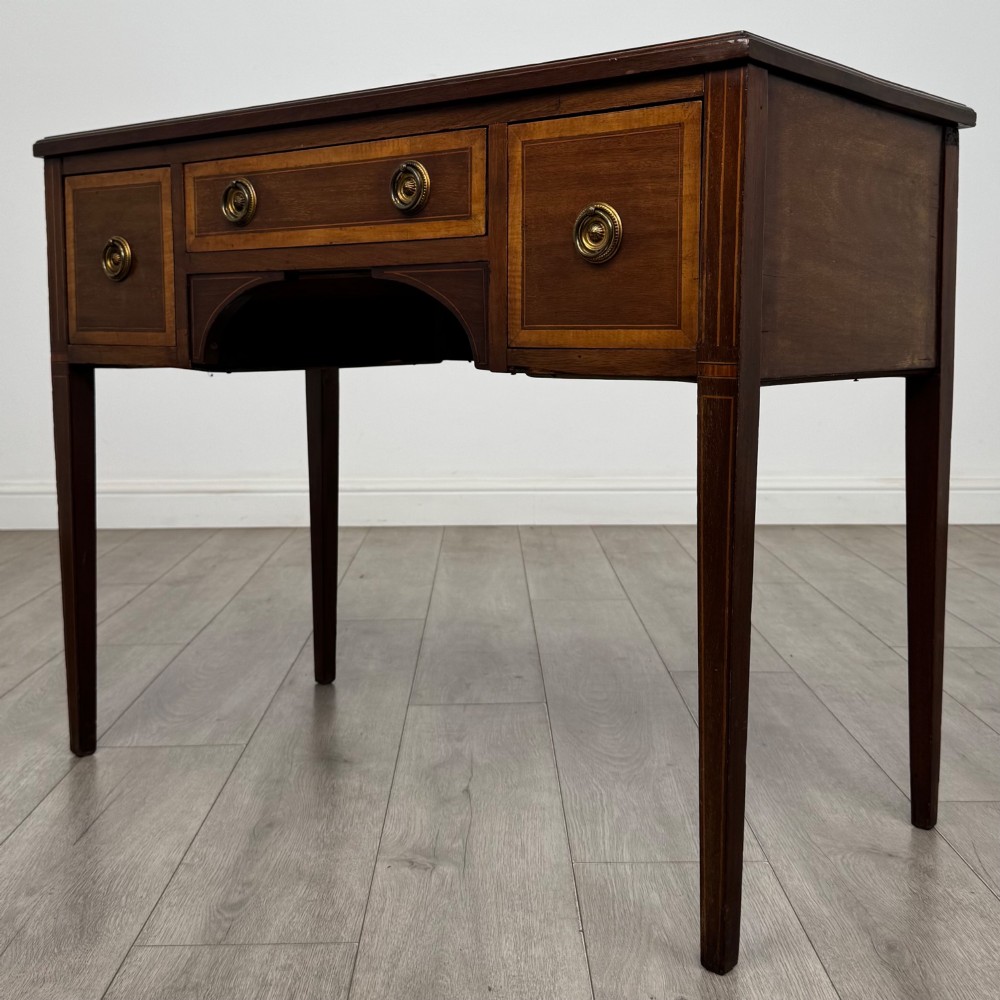 An Edwardian mahogany writing table featuring three drawers with satinwood crossbanding, brass ring pull handles, and square tapered legs. View II