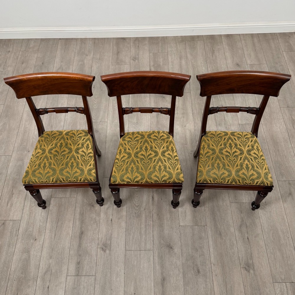 A set of six 19th-century William IV mahogany dining chairs featuring turned front legs, curved back rails, and green patterned fabric seats. View VII